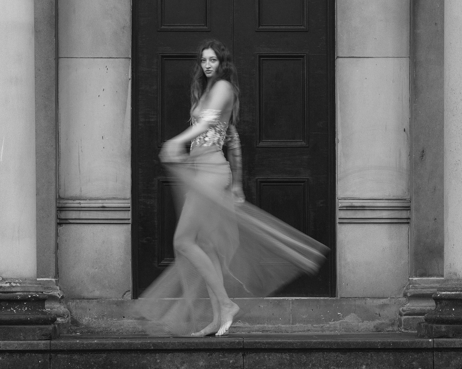 A bride poses in a bespoke weddings dress. The style of photography is editorial.