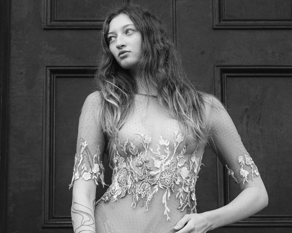 A bride poses in a bespoke weddings dress. The style of photography is editorial.