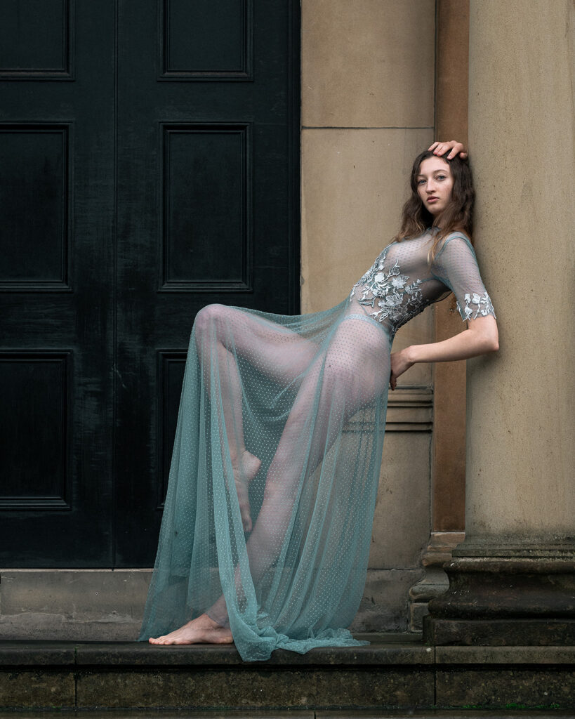 A bride poses in a bespoke weddings dress. The style of photography is editorial.