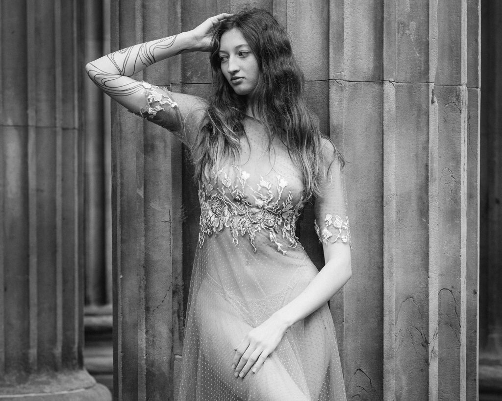 A bride poses in a bespoke weddings dress. The style of photography is editorial.