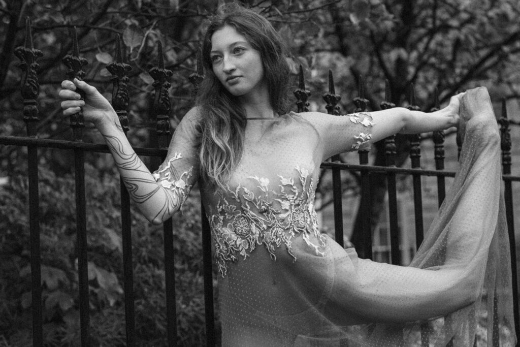A bride poses in a bespoke weddings dress. The style of photography is editorial. Editorial Wedding Photographer.