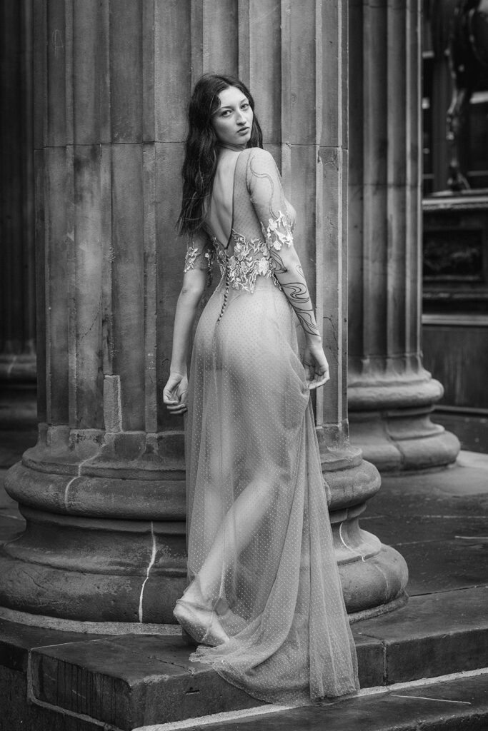 A bride poses in a bespoke weddings dress. The style of photography is editorial.