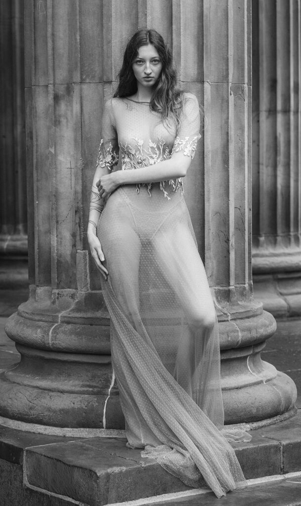 A bride poses in a bespoke weddings dress. The style of photography is editorial.