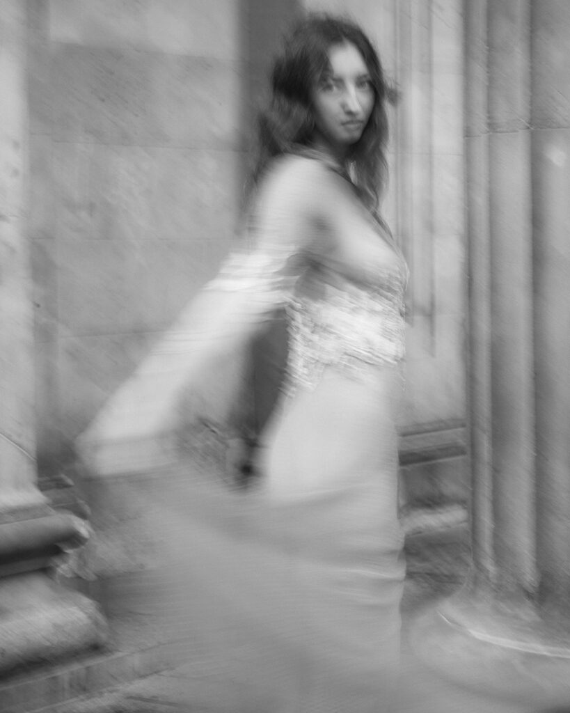 A bride poses in a bespoke weddings dress. The style of photography is editorial.