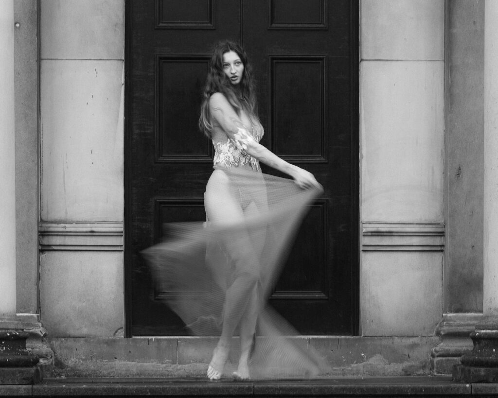 A bride poses in a bespoke weddings dress. The style of photography is editorial.