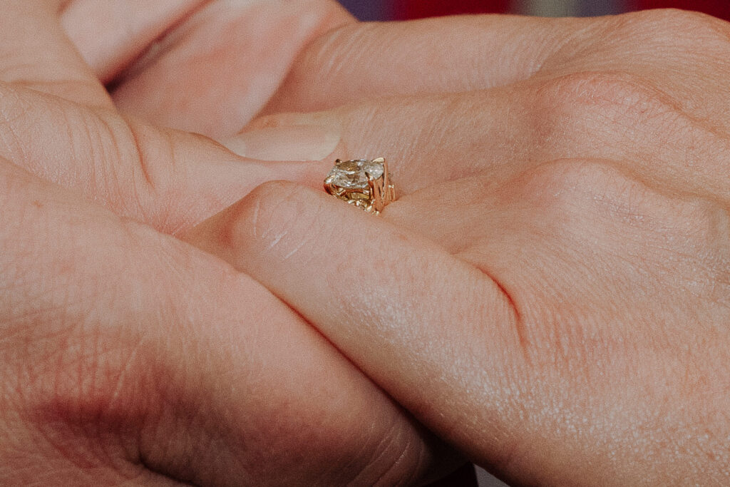 Close up of wedding ring, couple hold hands